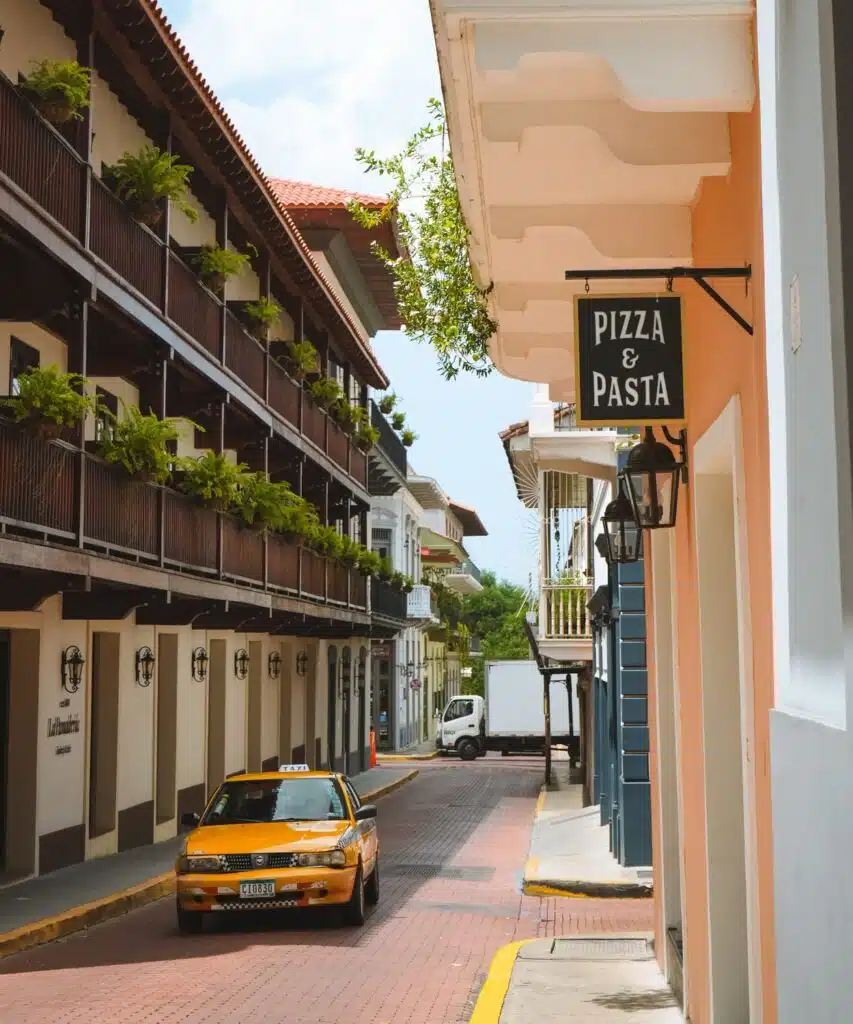 Yellow taxi is driving through Casco Viejo streets in Panama City