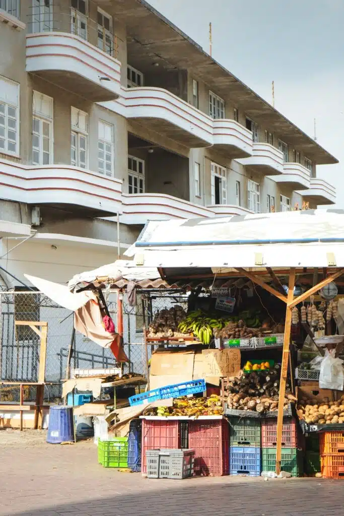 View of an art deco building in Santa Ana neighborhood with a vegetable market stall at the front