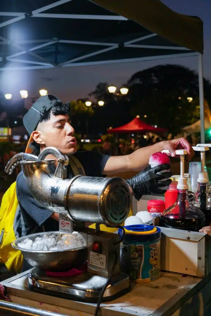 Man preparing shaved ice cones with syrup on Amador Causeway in Panama City