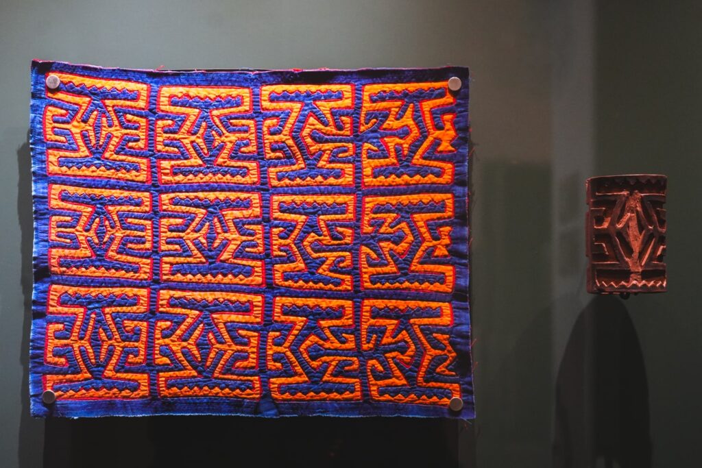 Mola and stamp displayed next to each other in museum in Panama City