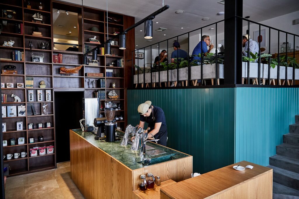 Man making coffee behind the bar inside Cafe Unido in Casco Viejo Panama