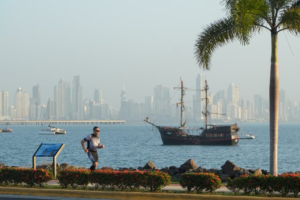 man running on amador causeway with pirate ship behind him