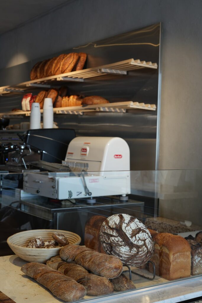 a display of bread, a bread cutting machine and a coffee machine at a cafe and bakery in panama city
