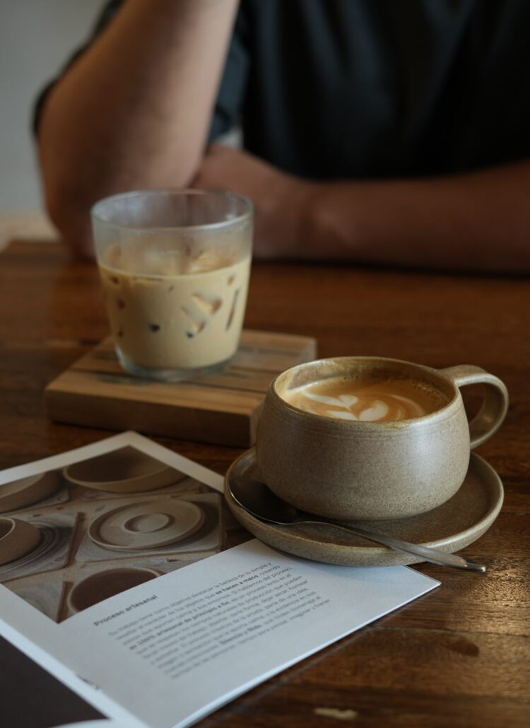 a cup of coffee with latte art and an iced coffee in a cafe