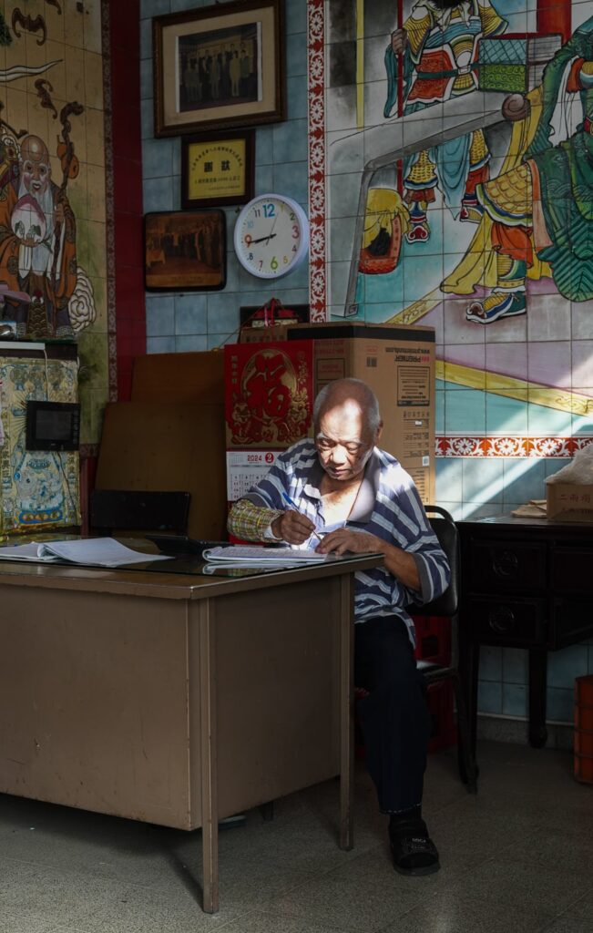 old man sitting inside a chinese temple in panama city